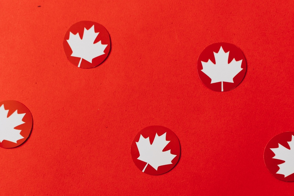 The Canadian maple leaf repeated across a red background