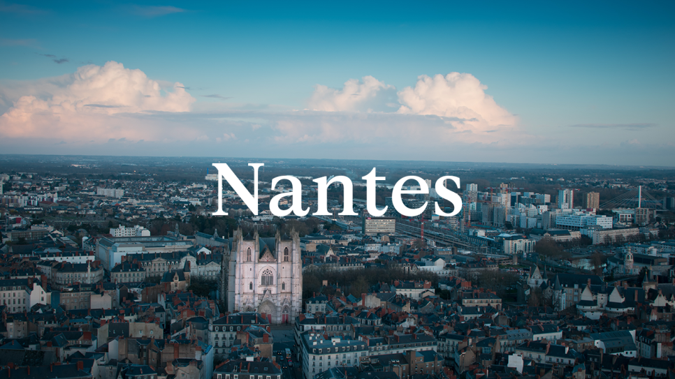 The city of Nantes with blue skies and the word Nantes in white as an overlay.