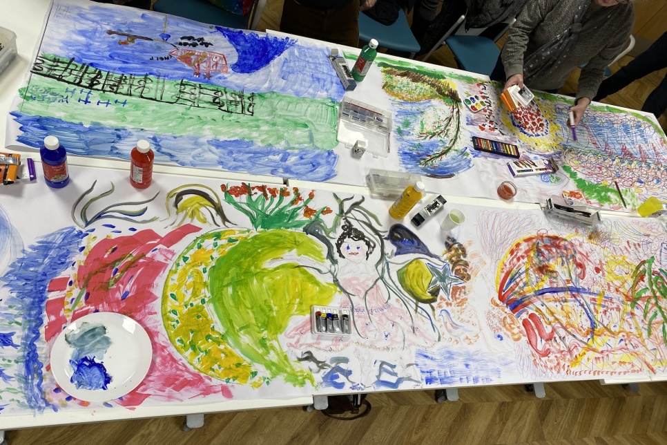 Large pieces of artwork and paint on a table