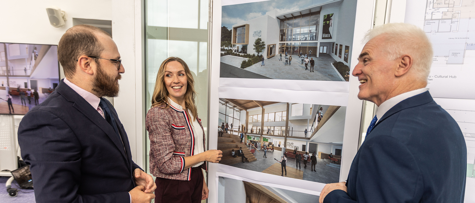 Three people looking at a set of visualisations and floor plans.