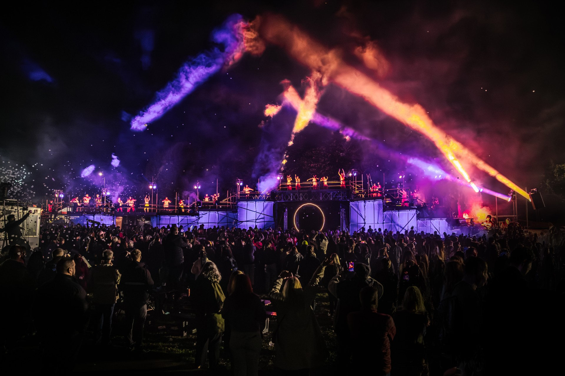 Performers on stage at night with neon lights