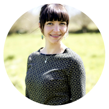 Azenor Kallag smiling in a printed jumper in a sunny field.