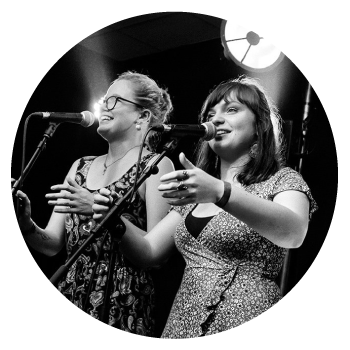 Sterenn Diridollou and Marine Lavigne on stage singing into microphones.