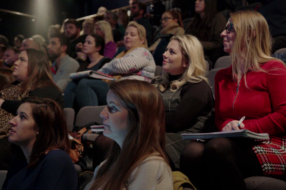 An audience with notebooks at a teacher training event