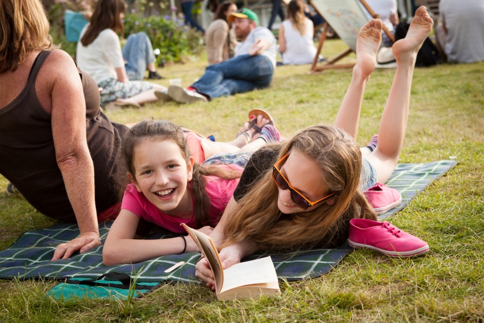 Two girls enjoying a book outdoors at the Hay Festival