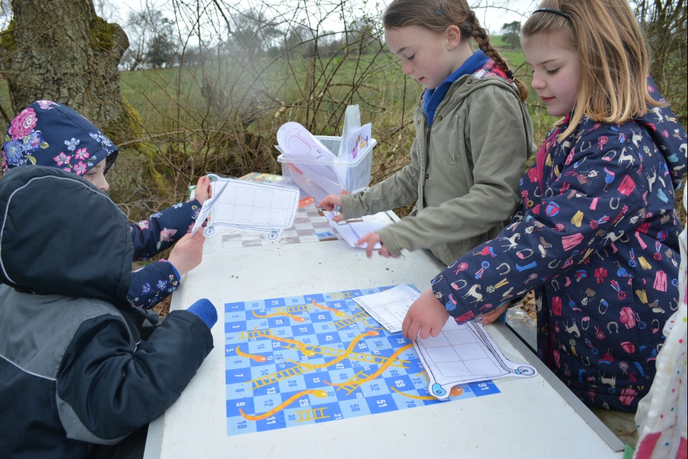 A group of students on a story trail in the schools forest area