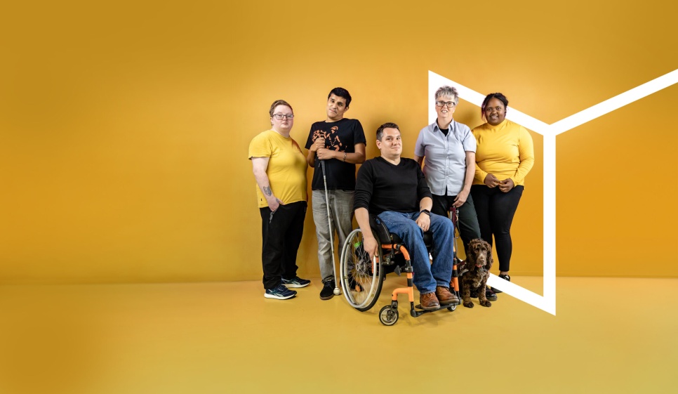 A group of people with different access requirements pose confidently. Photos by Karol Wyszynski. ‘Zena’ appears courtesy of Hearing Dogs for Deaf People.