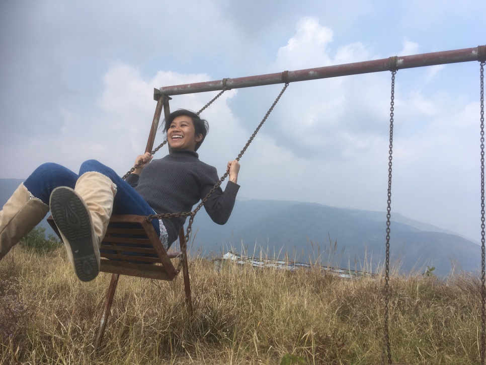 Lapdiang Swing on a two seater swing in the middle of a field