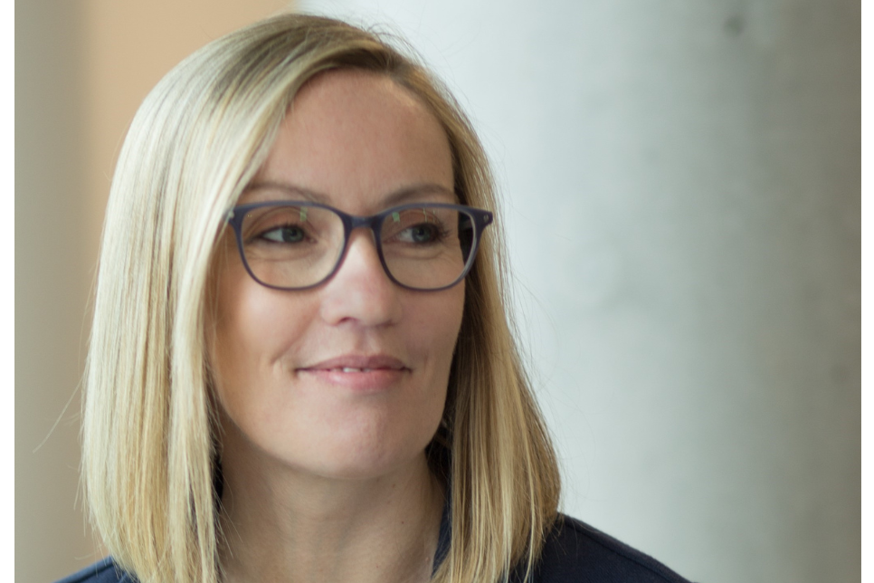 Close-up portrait of Lorna Virgo. She is smiling person and has blonde hair and glasses