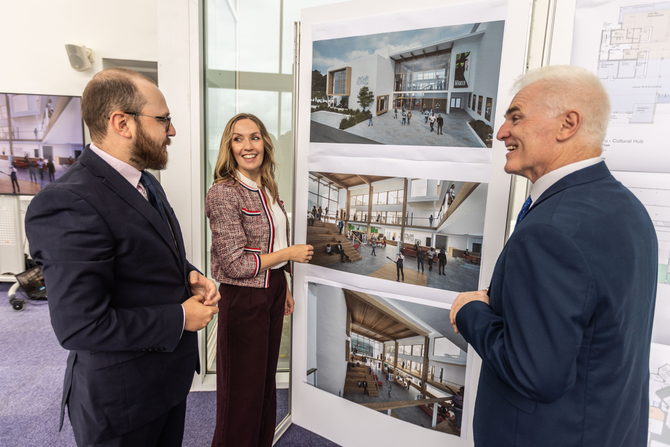 Three people looking at a set of visualisations and floor plans.