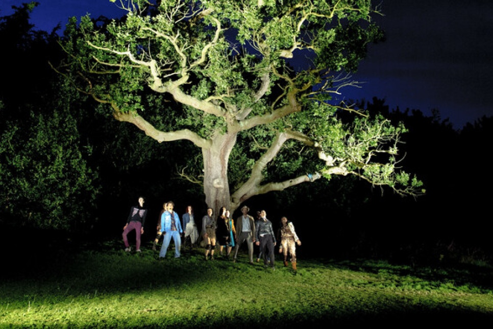 People standing under a tree at night