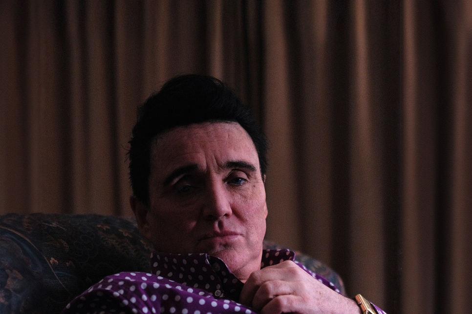 Photograph of a man sitting on a chair / Ffotograff o ddyn yn eistedd ar gadair 