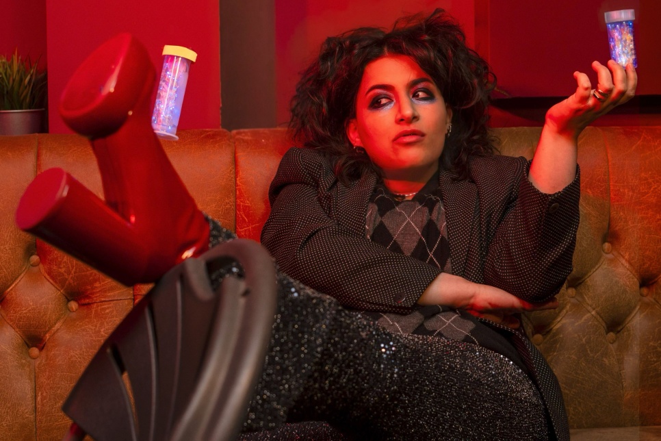 person sitting on a sofa with their leg in the air wearing red platform boots