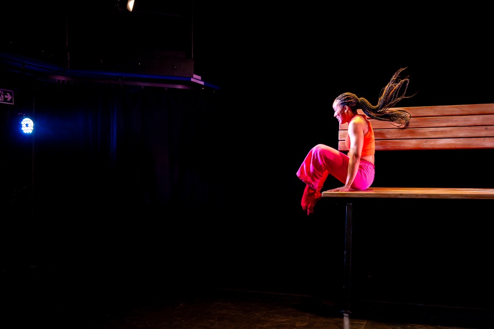 Photograph of a dancer on a large bench / Ffotograff o berson yn dawnsio ar fainc fawr