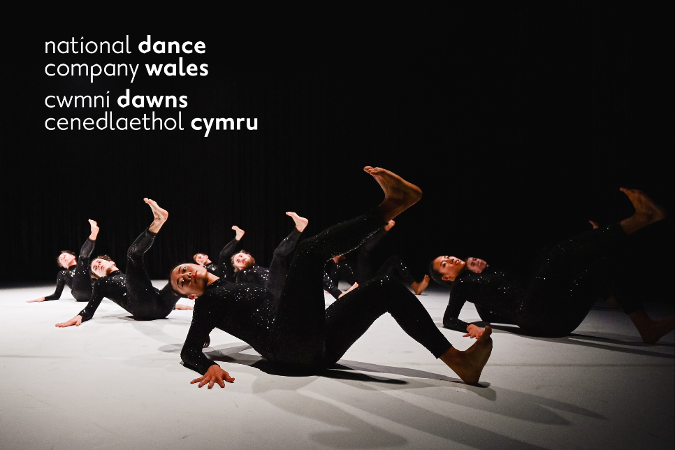 dancers dressed in black with  National Dance Company Wales logo in left hand corner